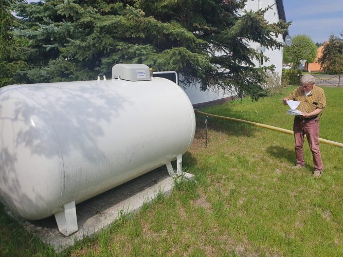 Zbiornik na gaz płynny LPG zamontowany w przepisowy sposób na ogrodzie